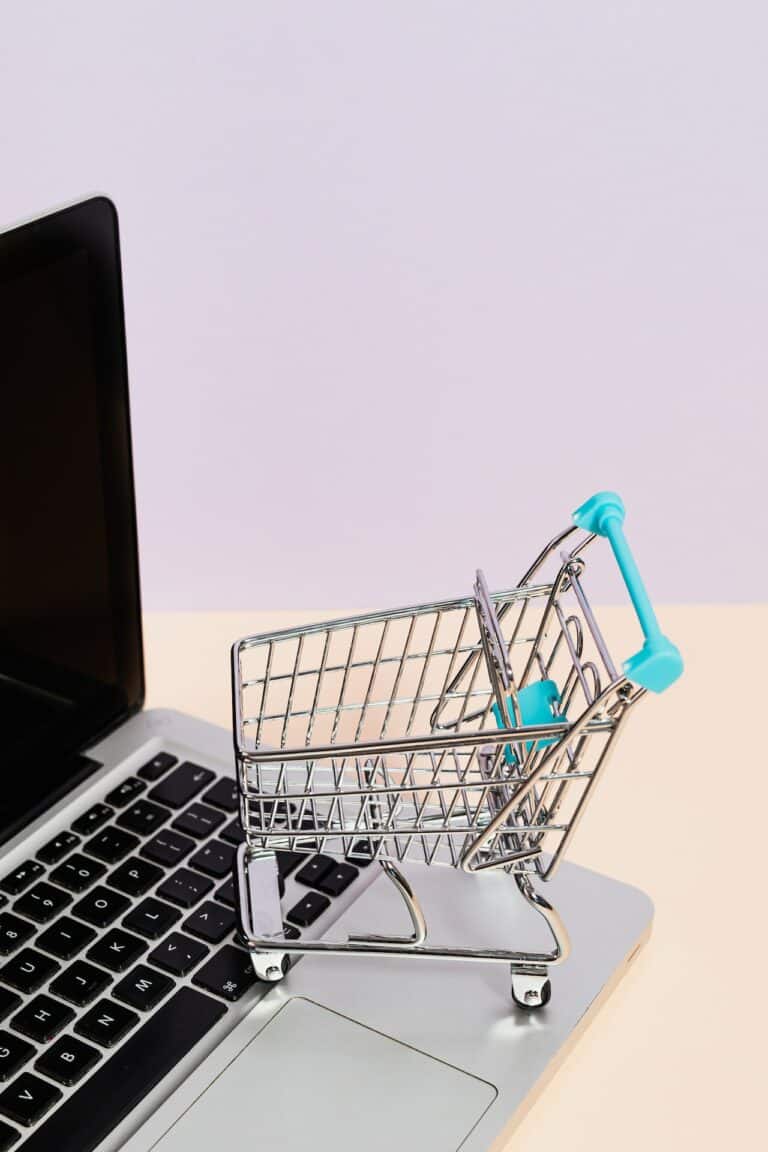 A little shopping cart standing on a laptop by Karolina Grabowska